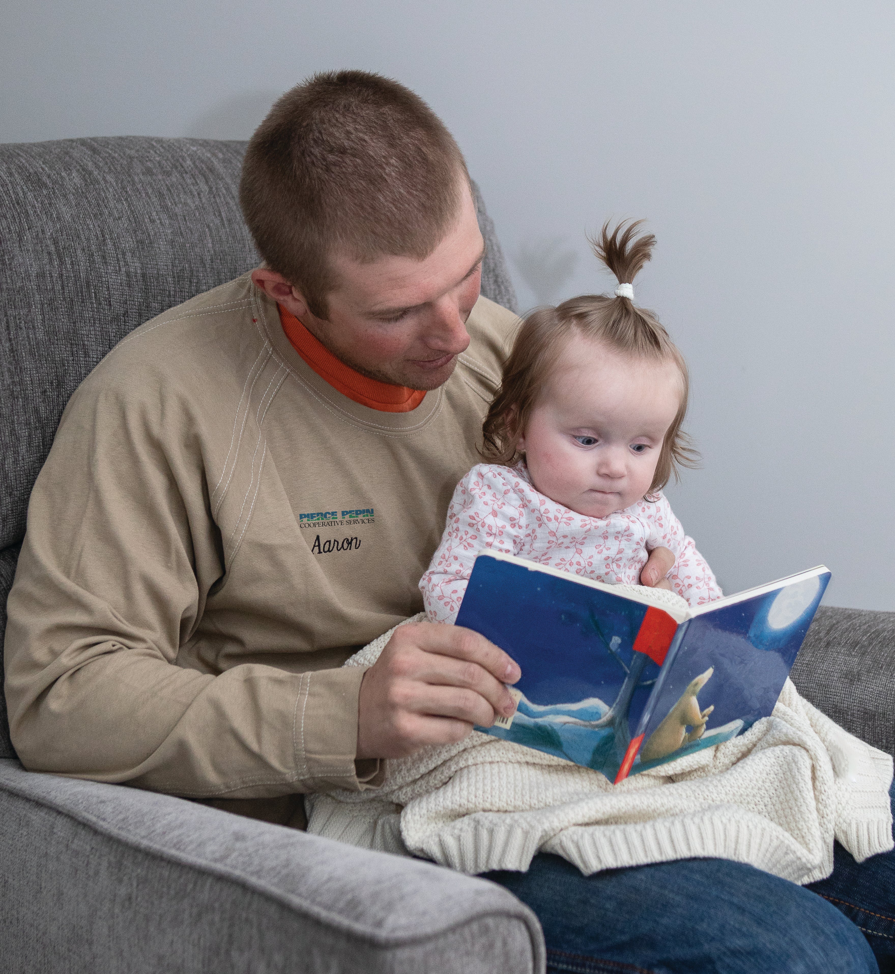 Aaron reading a book to his daughter, Lennin